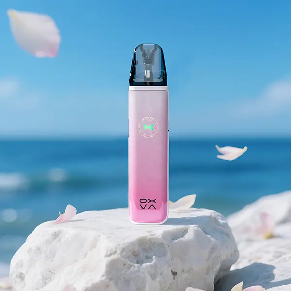 Oxva Xlim Go 2 Pod Kit in Rosa, stehend auf Stein vor Meereshintergrund