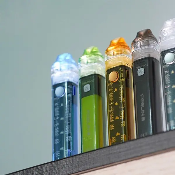 Nevoks Feelin C1 Pod Kit in vier Farben aufrecht stehend auf Regal, schlankes Design